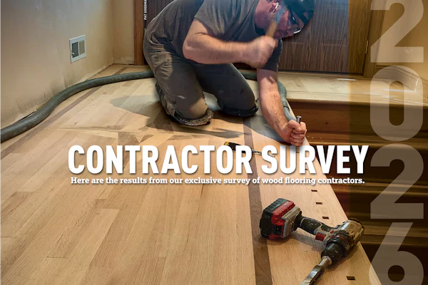 Wood flooring contractor kneeling while installing hardwood flooring with power tools on a residential floor