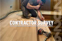 Wood flooring contractor kneeling while installing hardwood flooring with power tools on a residential floor