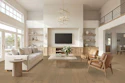 Modern open-concept living room with neutral furnishings, wood flooring, wall-mounted TV, and abundant natural light from large windows