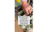 Technician inspecting electrical switches and fuses inside industrial machinery during maintenance checkup